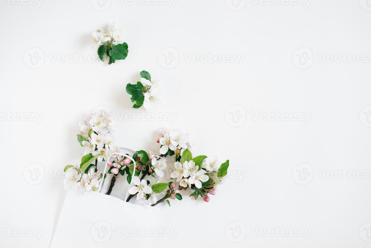 Apple tree flowers in a shopping bag on a white background with copy space. Top view and flat lay. The concept of spring discounts in stores. photo