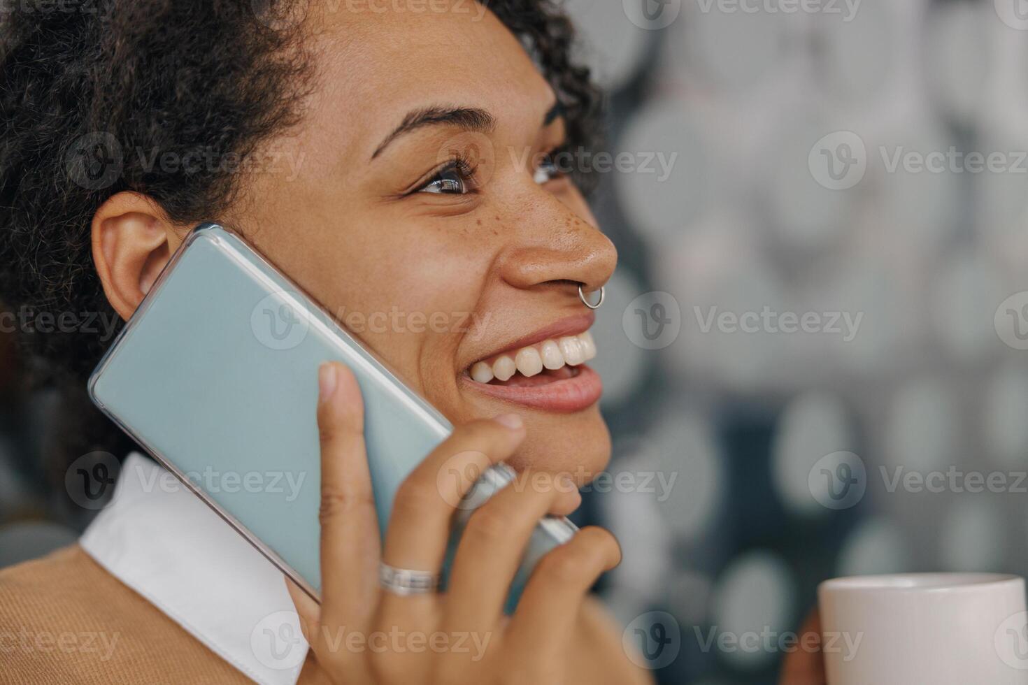 Close up of businesswoman is talking phone with client while standing on modern office background photo