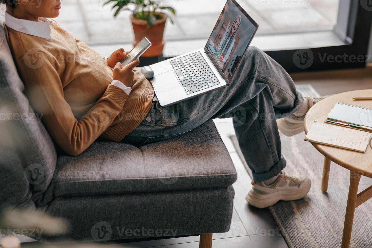 Close up of female freelancer have conference with client and use phone sitting in coworking photo
