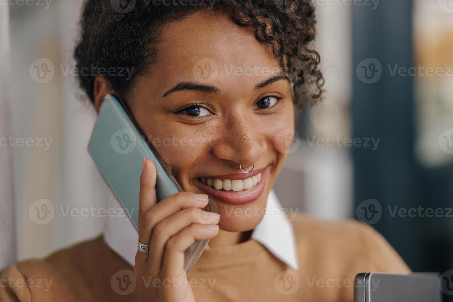 Close up of female freelancer is talking phone with client while standing on coworking background photo