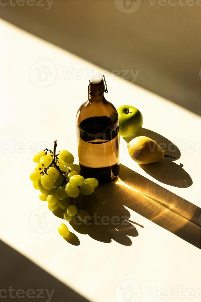 a bottle of oil grapes and apples on a table photo