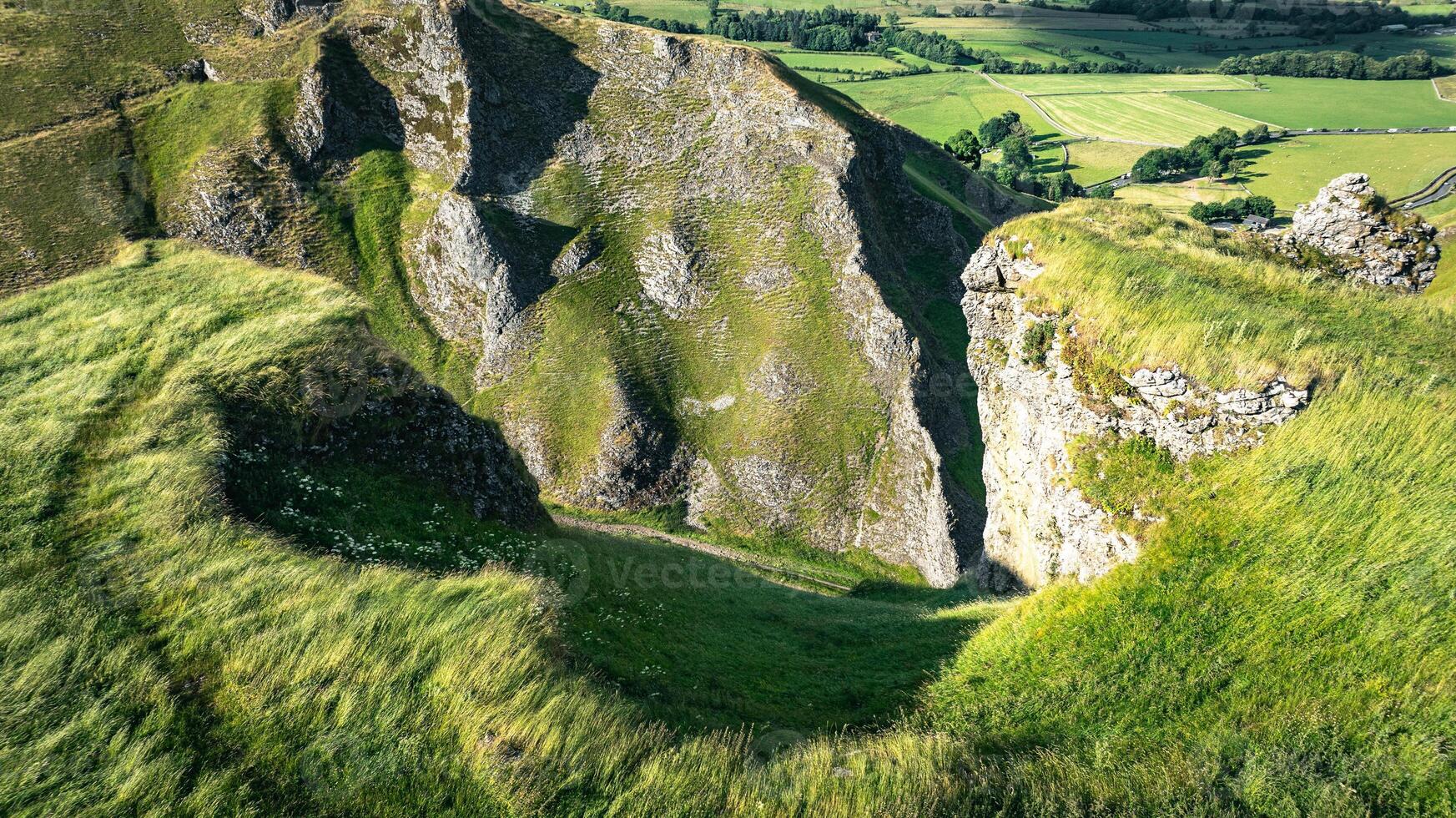 Curvy road between two hills in Yorkshire, Winnats Pass, UK photo