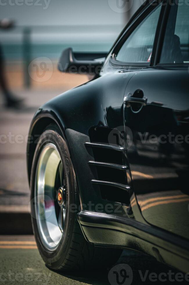 Rear quoter of a sports car on a seafront of Brighton beach. photo