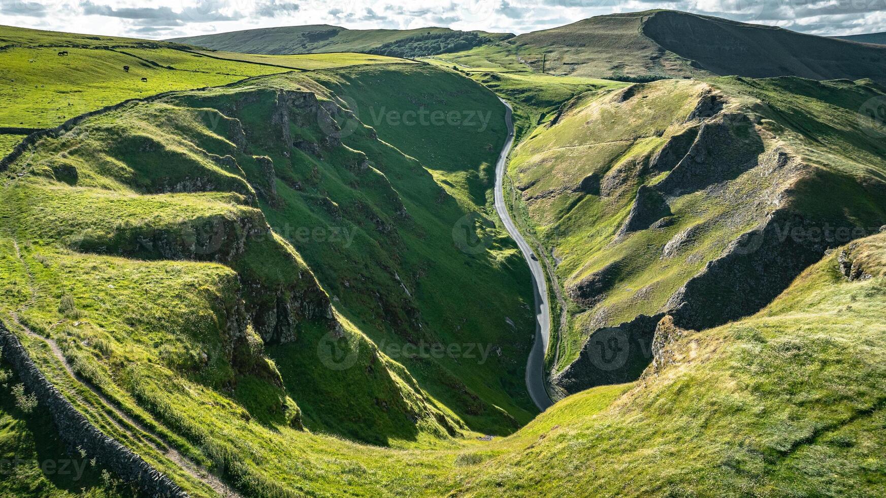 Curvy road between two hills in Yorkshire, Winnats Pass, UK photo