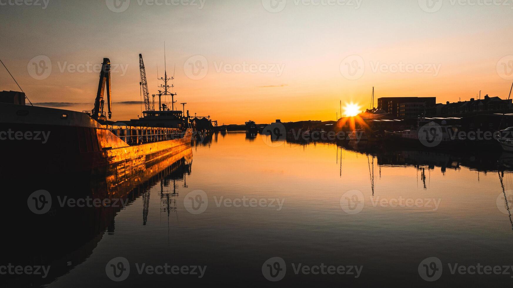 Calm and quiet shipyard with water reflections on a sunset, Brighton and Hove, East Sussex, UK photo