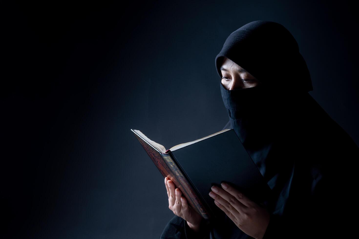 Portrait Asian Muslim woman standing and reading the Quran and appreciates and faith photo