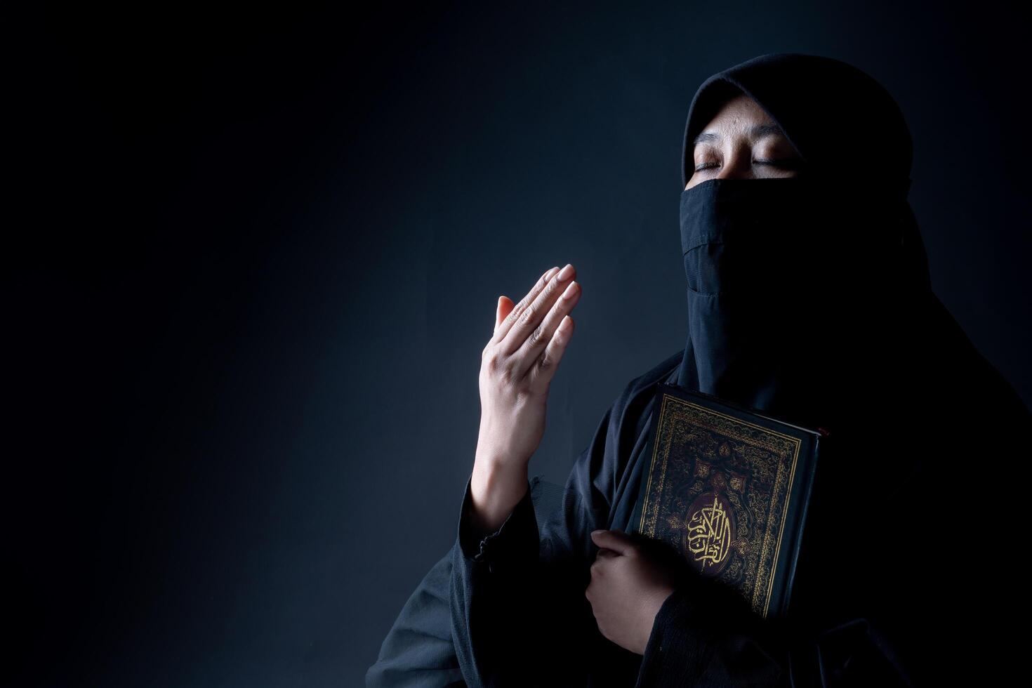 Portrait Asian Muslim woman standing and reading the Quran and appreciates and faith photo