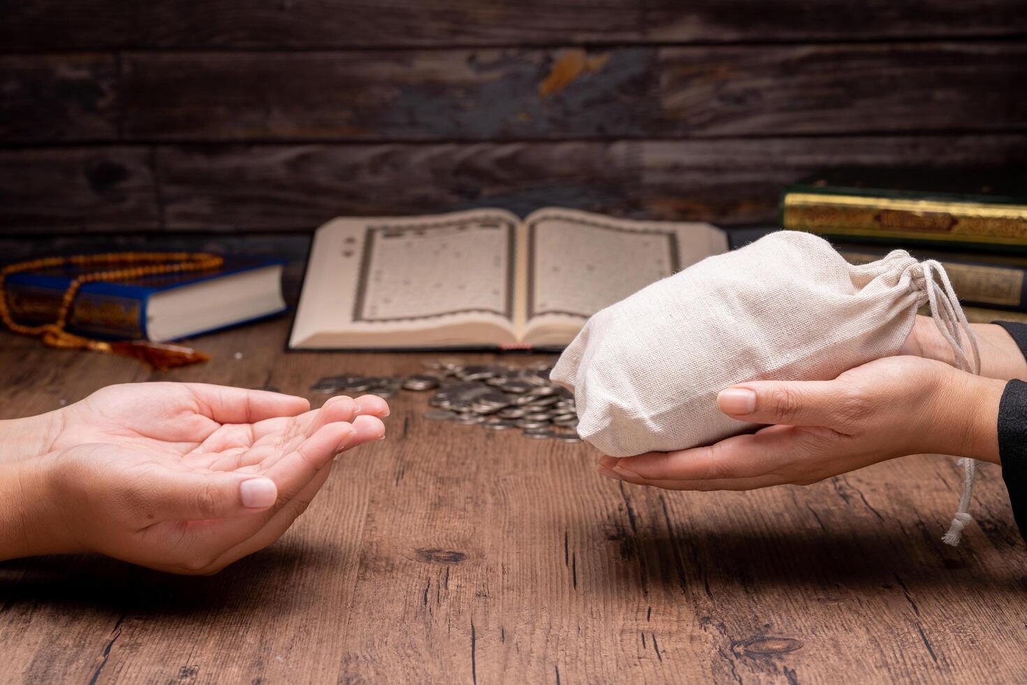 Hands holding a wooden bowl of rice grains and money bag for zakat, Islamic zakat concept. Muslims help the poor and needy. Conceptual shoot for property, income, and fitrah zakat. photo