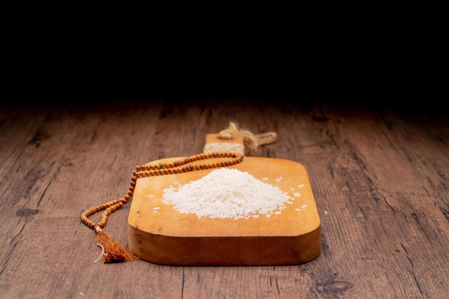 Hands holding a wooden bowl of rice grains and money bag for zakat, Islamic zakat concept. Muslims help the poor and needy. Conceptual shoot for property, income, and fitrah zakat. photo