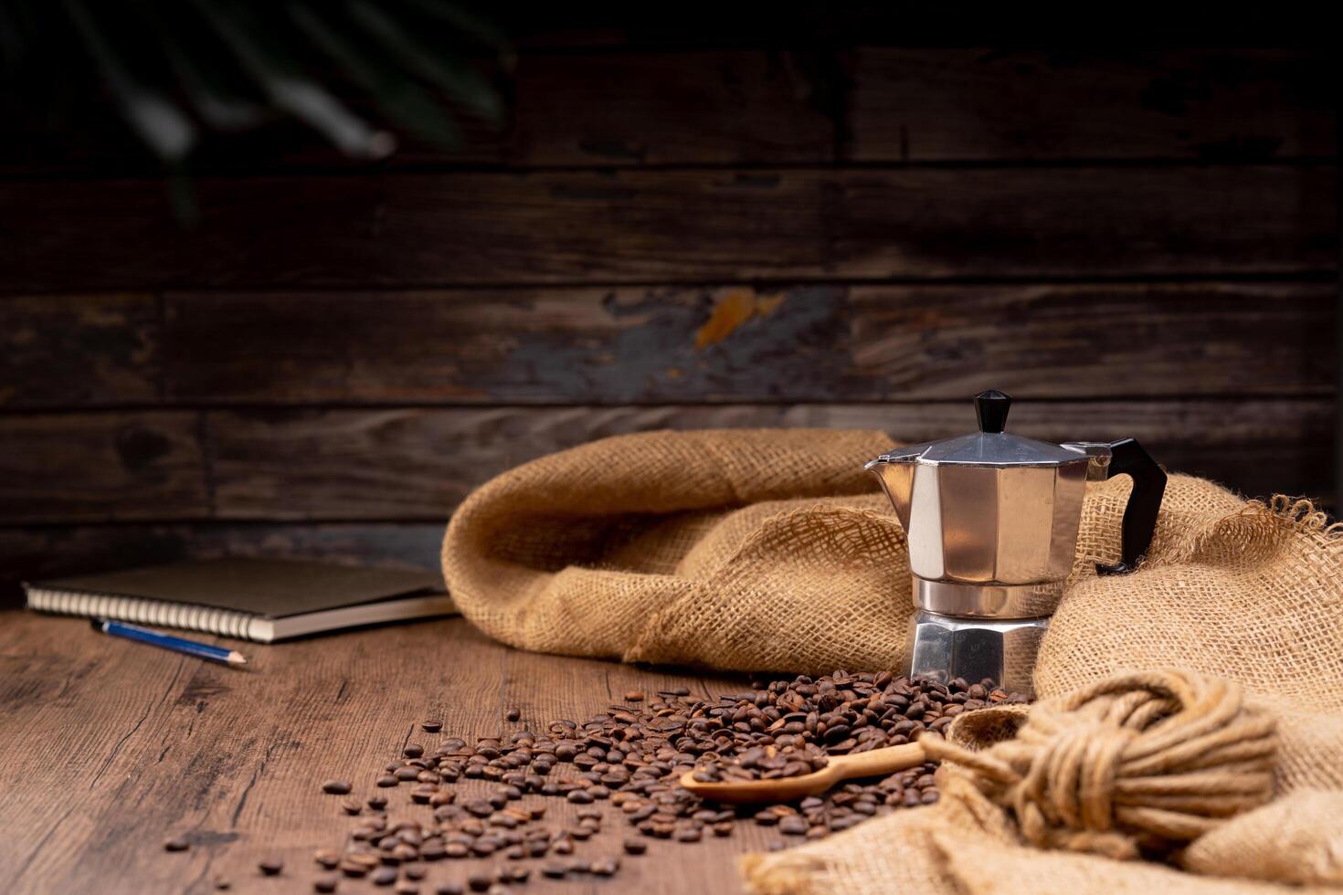 The picture of coffee beans stacked together on a wooden floor in a warm, light atmosphere, on a dark background, with copy space. photo