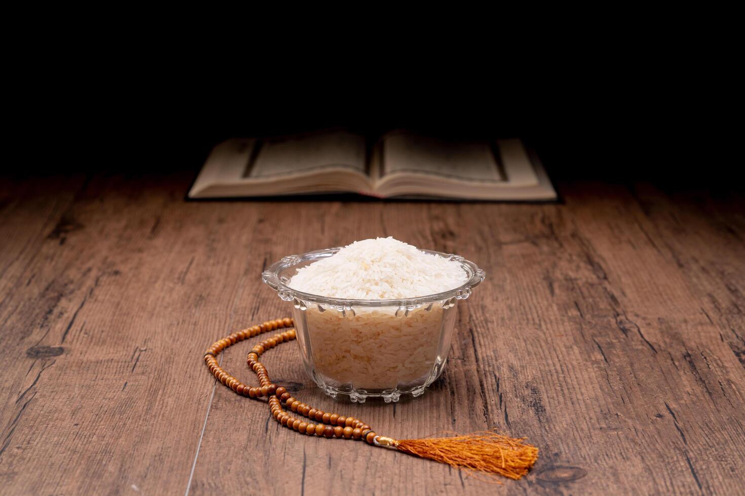 Hands holding a wooden bowl of rice grains and money bag for zakat, Islamic zakat concept. Muslims help the poor and needy. Conceptual shoot for property, income, and fitrah zakat. photo