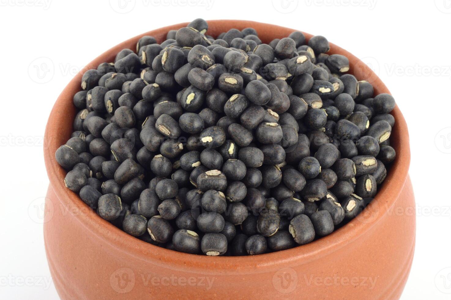 Urad dal, black gram, Vigna mungo in clay pot on white background photo