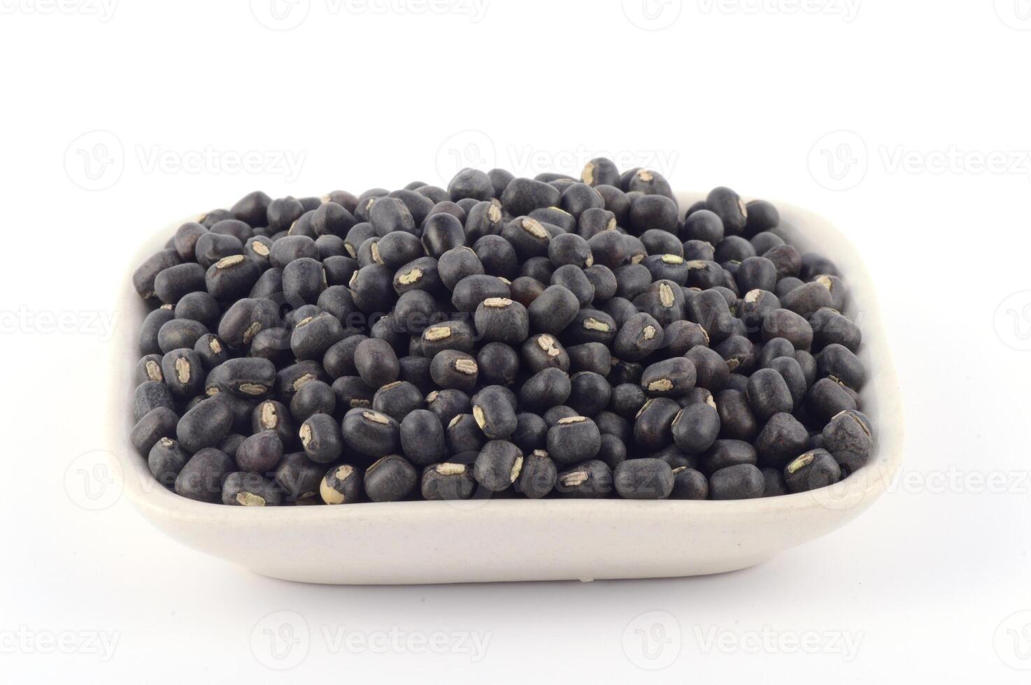 Urad dal, black gram, Vigna mungo in white plate on white background photo
