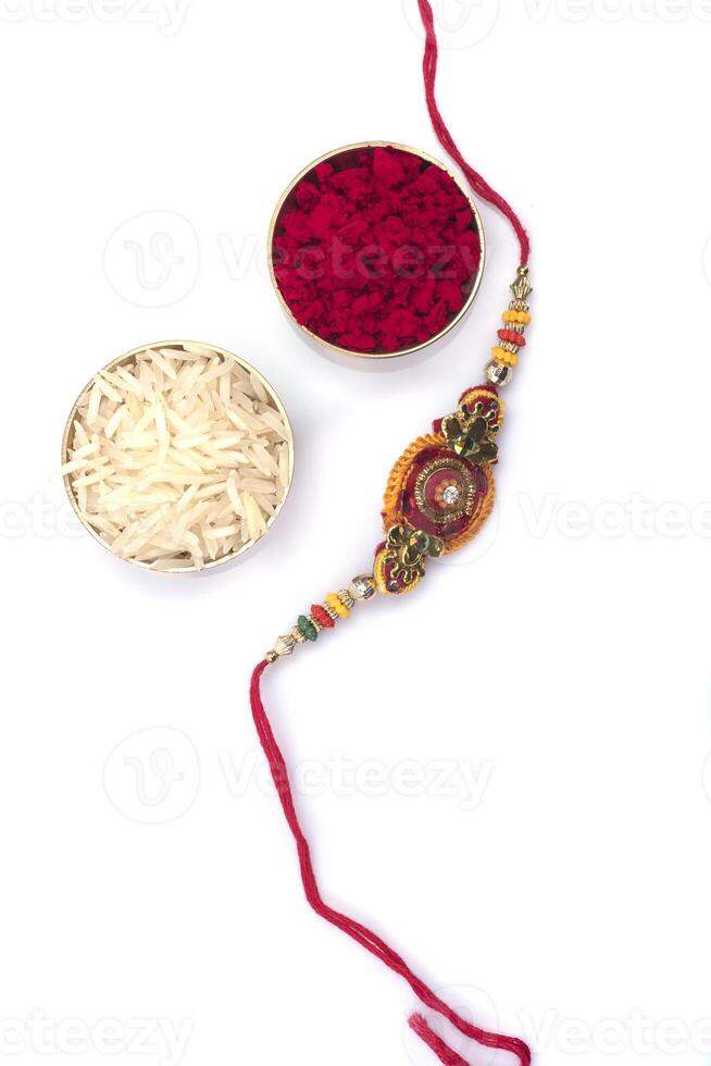 Indian festival Raksha Bandhan background with an elegant Rakhi on a white background. A traditional Indian wrist band which is a symbol of love between Brothers and Sisters photo