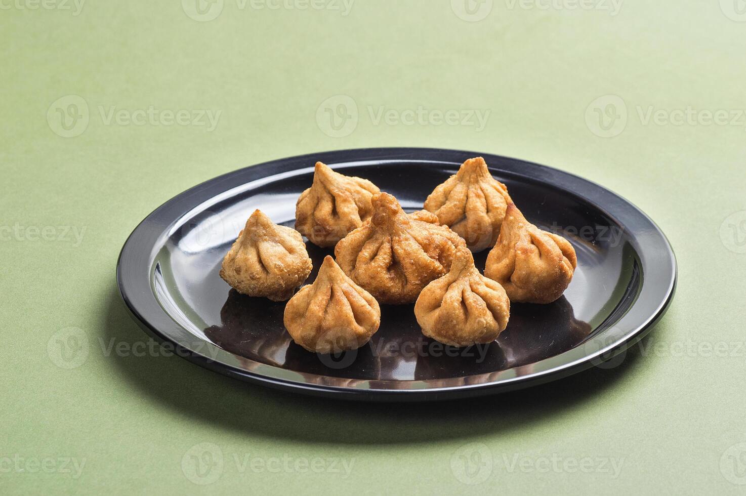 Indian Food Modak on green background, Maharashtra Sweet Dish, favourite sweet of lord ganesha, greeting card design. Copy-space. photo