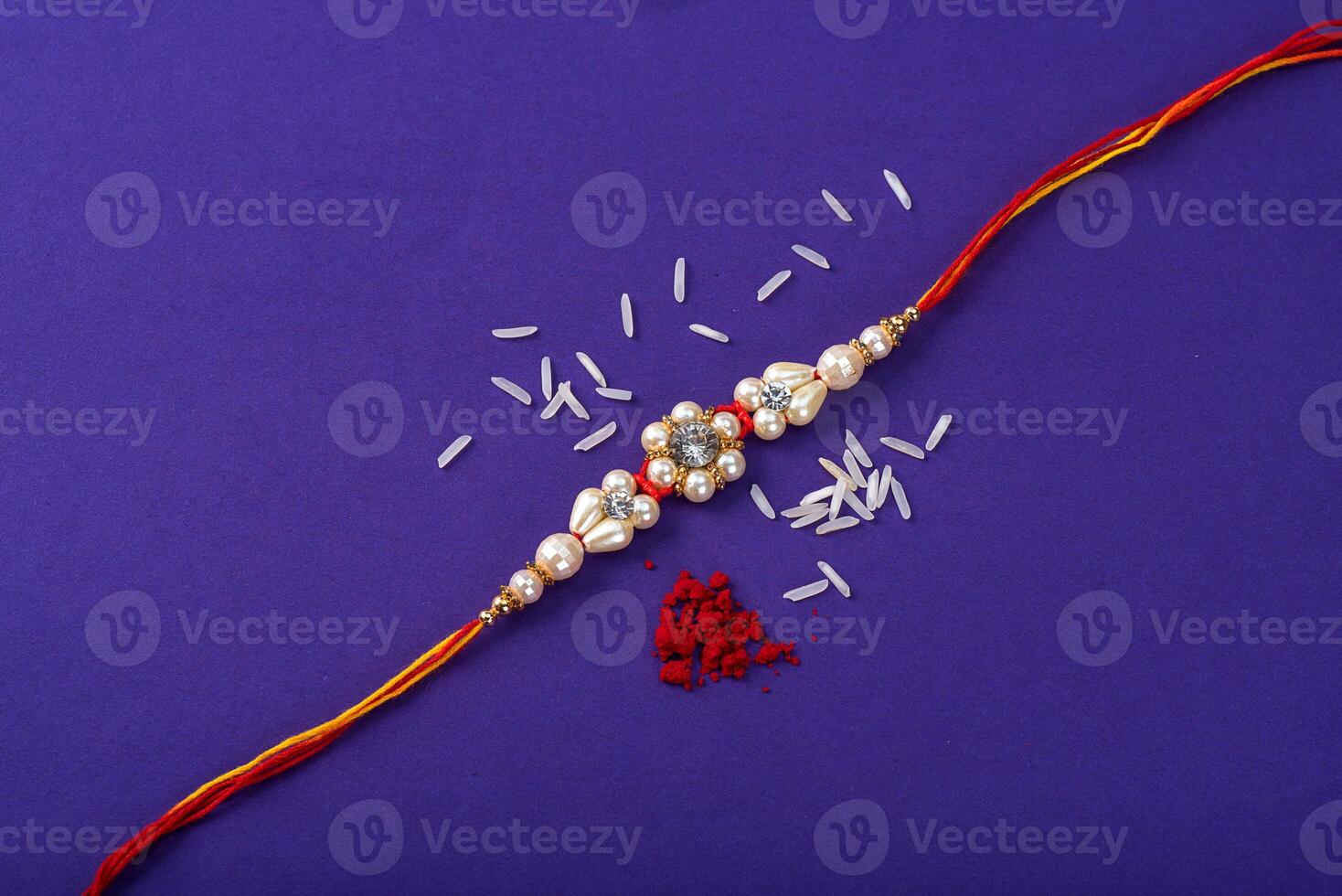 Raksha Bandhan Rakhi with rice grains and kumkum. An Indian festive background. Traditional Indian wrist band which is a symbol of love between Brothers and Sisters. photo
