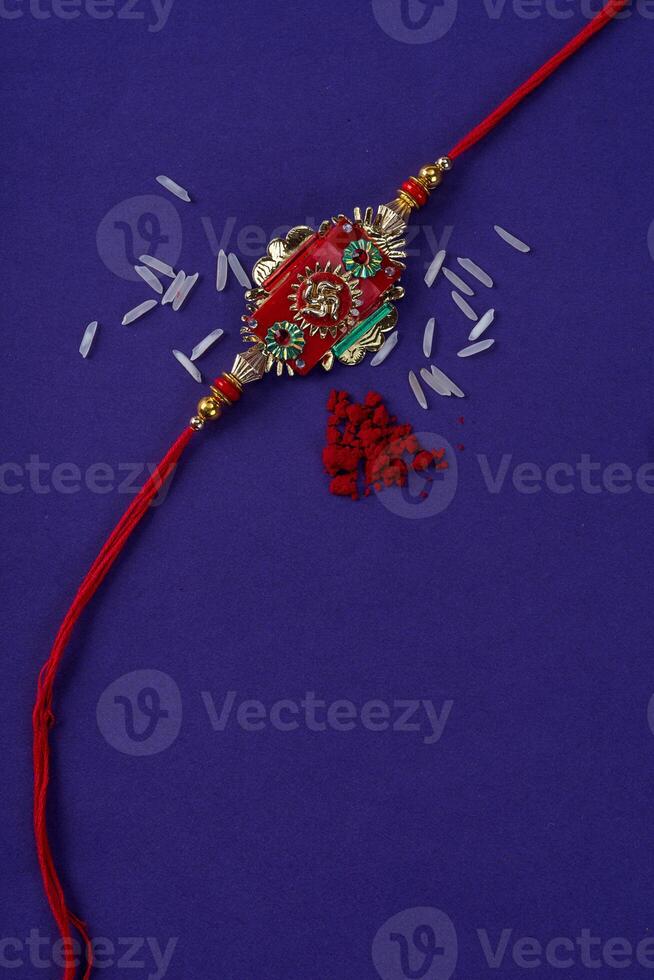 Raksha Bandhan Rakhi with rice grains and kumkum. An Indian festive background. Traditional Indian wrist band which is a symbol of love between Brothers and Sisters. photo