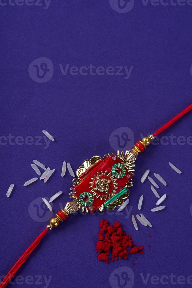 Raksha Bandhan Rakhi with rice grains and kumkum. An Indian festive background. Traditional Indian wrist band which is a symbol of love between Brothers and Sisters. photo