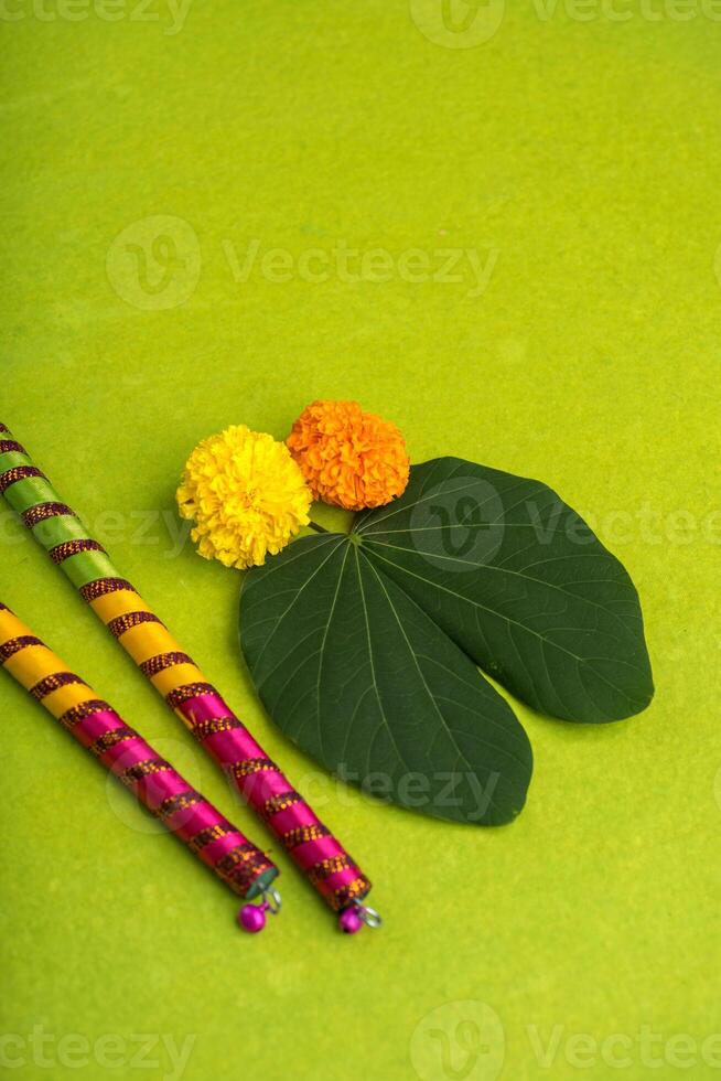 Two colorful rakhi sticks and a leaf on a green background photo
