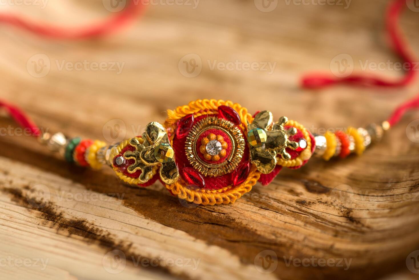 Indian festival Raksha Bandhan background with an elegant Rakhi, Rice Grains and Kumkum. A traditional Indian wrist band which is a symbol of love between Brothers and Sisters. photo