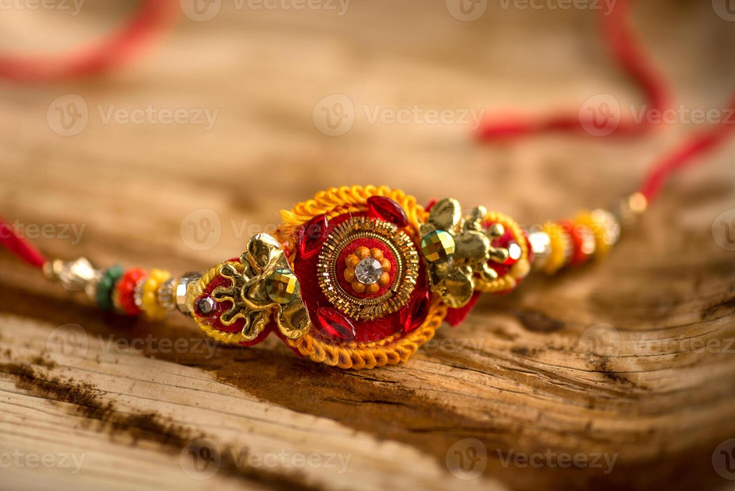 Indian festival Raksha Bandhan background with an elegant Rakhi, Rice Grains and Kumkum. A traditional Indian wrist band which is a symbol of love between Brothers and Sisters. photo