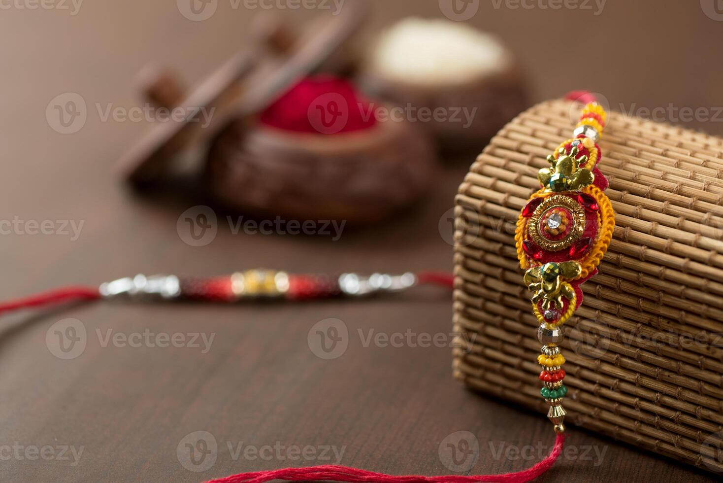 Indian festival Raksha Bandhan background with an elegant Rakhi, Rice Grains and Kumkum. A traditional Indian wrist band which is a symbol of love between Brothers and Sisters. photo