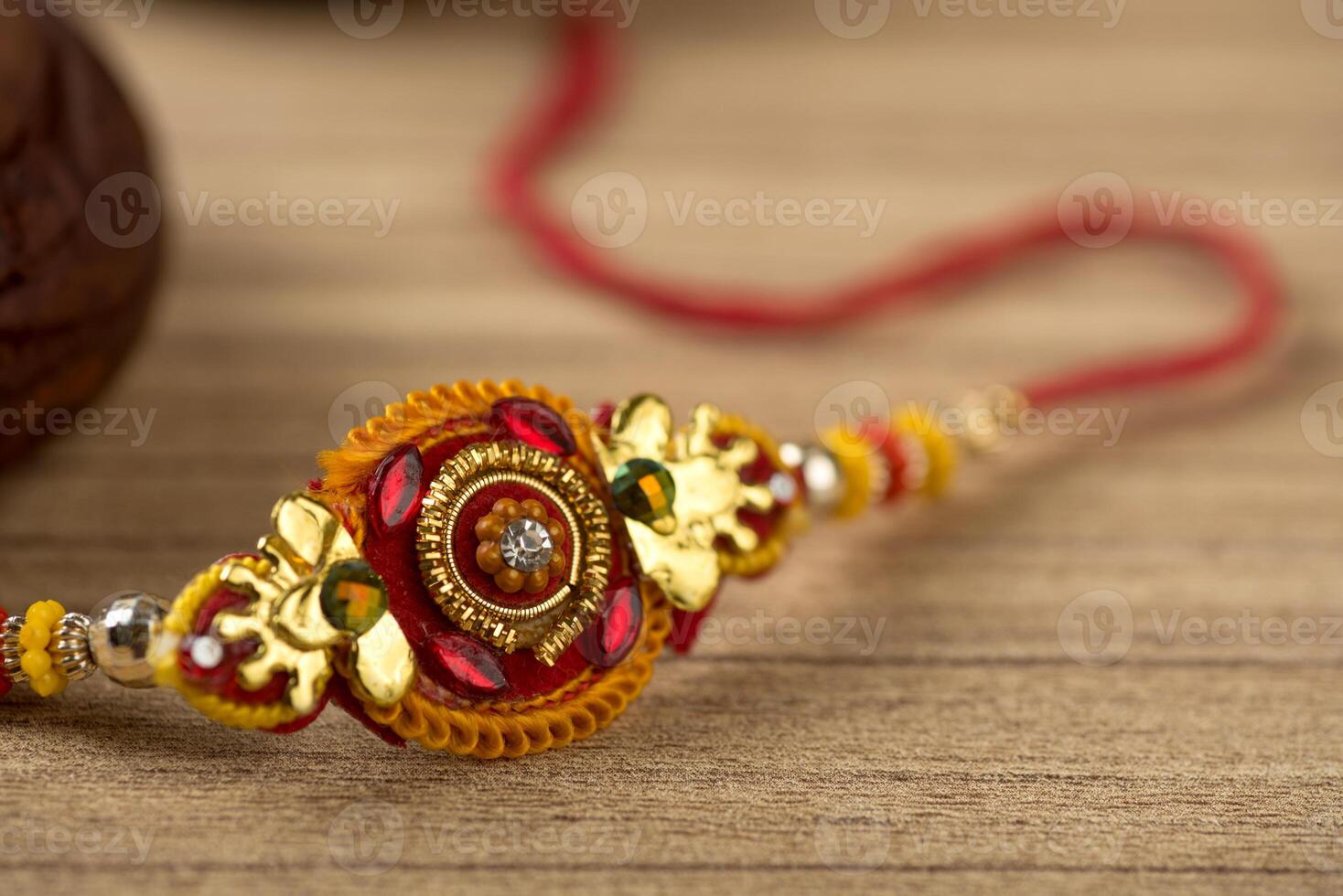 Indian festival Raksha Bandhan background with an elegant Rakhi, Rice Grains and Kumkum. A traditional Indian wrist band which is a symbol of love between Brothers and Sisters. photo