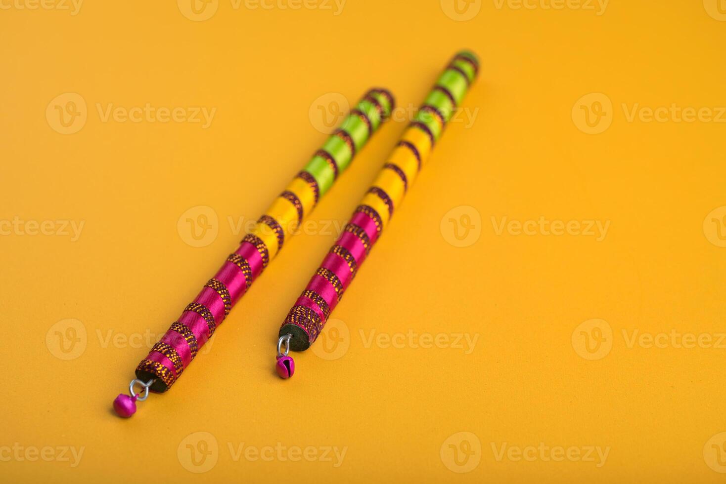 Dandiya sticks on a yellow background. Raas Garba or Dandiya Raas is the traditional folk dance form the state of Gujarat, Rajasthan in India. photo