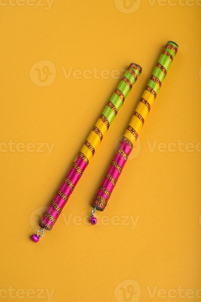 Dandiya sticks on a yellow background. Raas Garba or Dandiya Raas is the traditional folk dance form the state of Gujarat, Rajasthan in India. photo