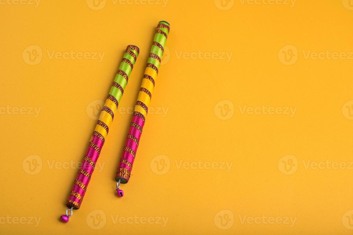 Dandiya sticks on a yellow background. Raas Garba or Dandiya Raas is the traditional folk dance form the state of Gujarat, Rajasthan in India. photo