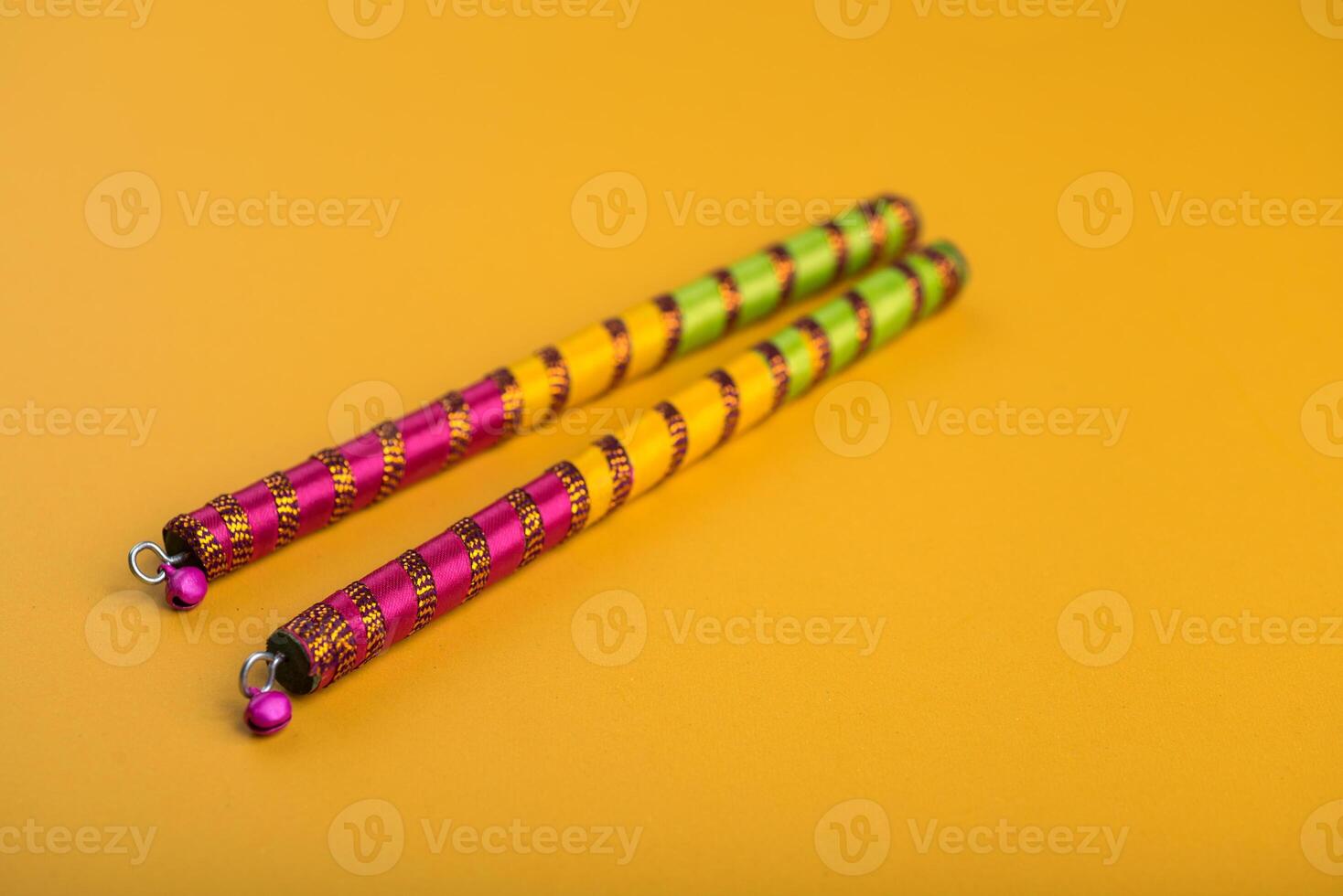 Dandiya sticks on a yellow background. Raas Garba or Dandiya Raas is the traditional folk dance form the state of Gujarat, Rajasthan in India. photo