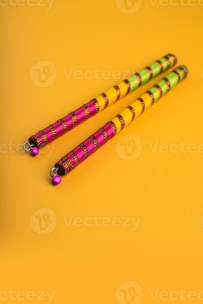 Dandiya sticks on a yellow background. Raas Garba or Dandiya Raas is the traditional folk dance form the state of Gujarat, Rajasthan in India. photo