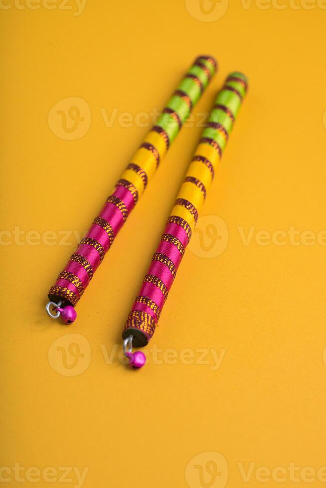 Dandiya sticks on a yellow background. Raas Garba or Dandiya Raas is the traditional folk dance form the state of Gujarat, Rajasthan in India. photo