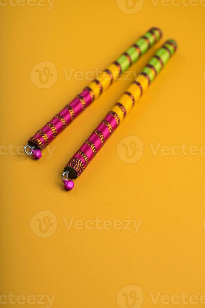 Dandiya sticks on a yellow background. Raas Garba or Dandiya Raas is the traditional folk dance form the state of Gujarat, Rajasthan in India. photo