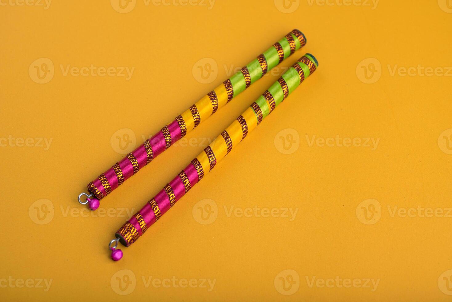 Dandiya sticks on a yellow background. Raas Garba or Dandiya Raas is the traditional folk dance form the state of Gujarat, Rajasthan in India. photo