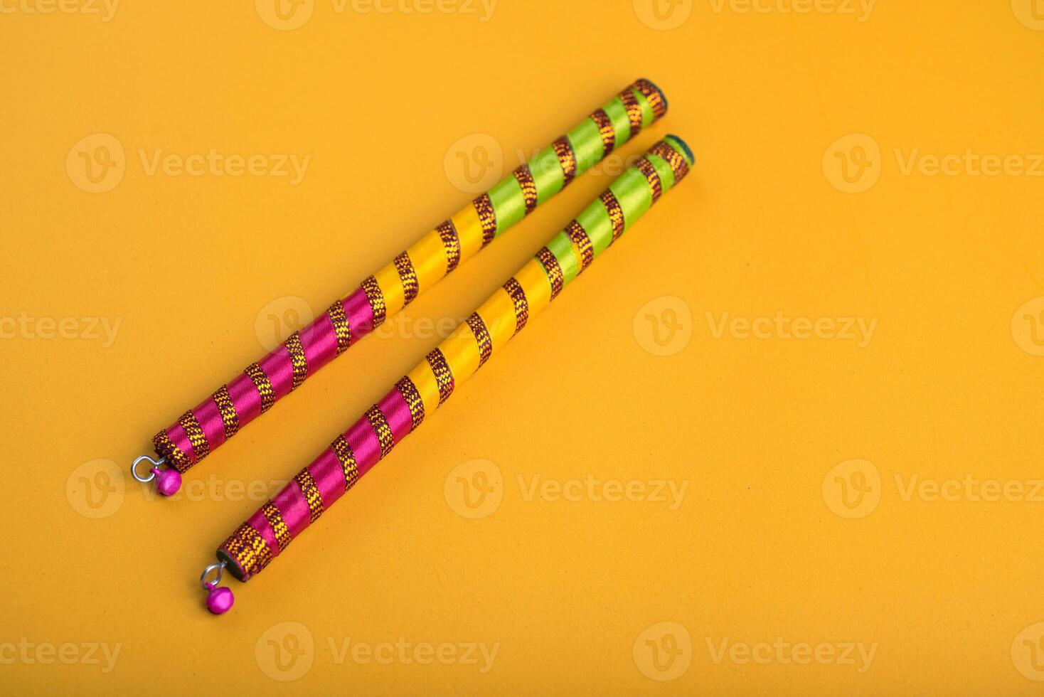 Dandiya sticks on a yellow background. Raas Garba or Dandiya Raas is the traditional folk dance form the state of Gujarat, Rajasthan in India. photo