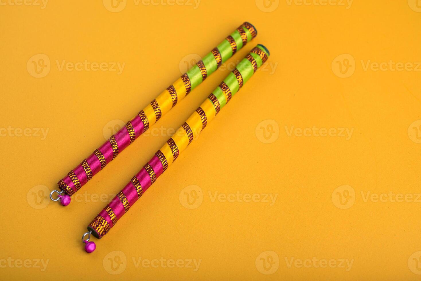 Dandiya sticks on a yellow background. Raas Garba or Dandiya Raas is the traditional folk dance form the state of Gujarat, Rajasthan in India. photo