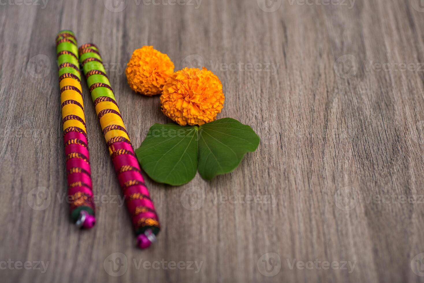 Two colorful sticks with flowers on a wooden table photo
