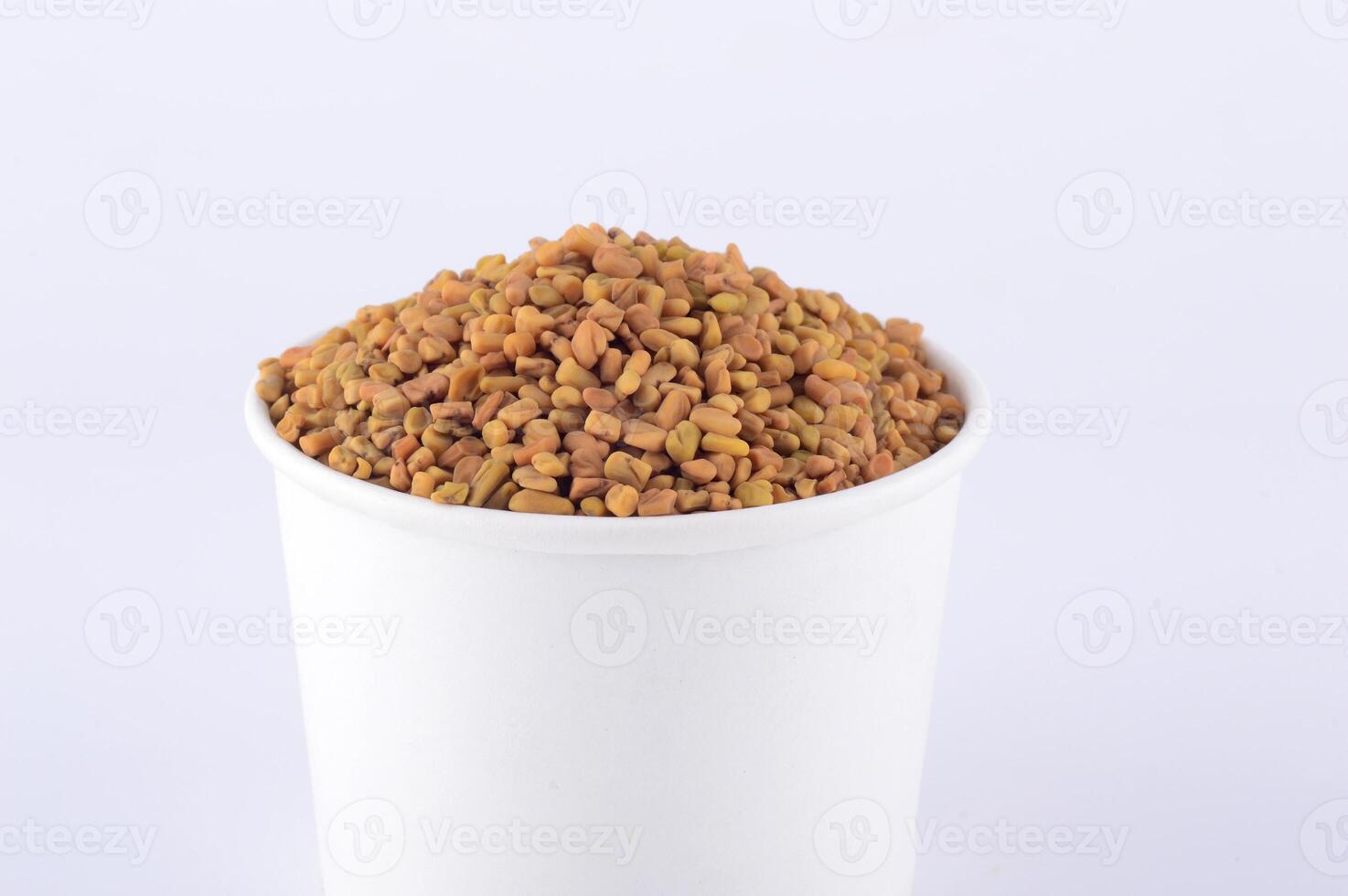 Fenugreek seeds in white plate isolated on white background photo