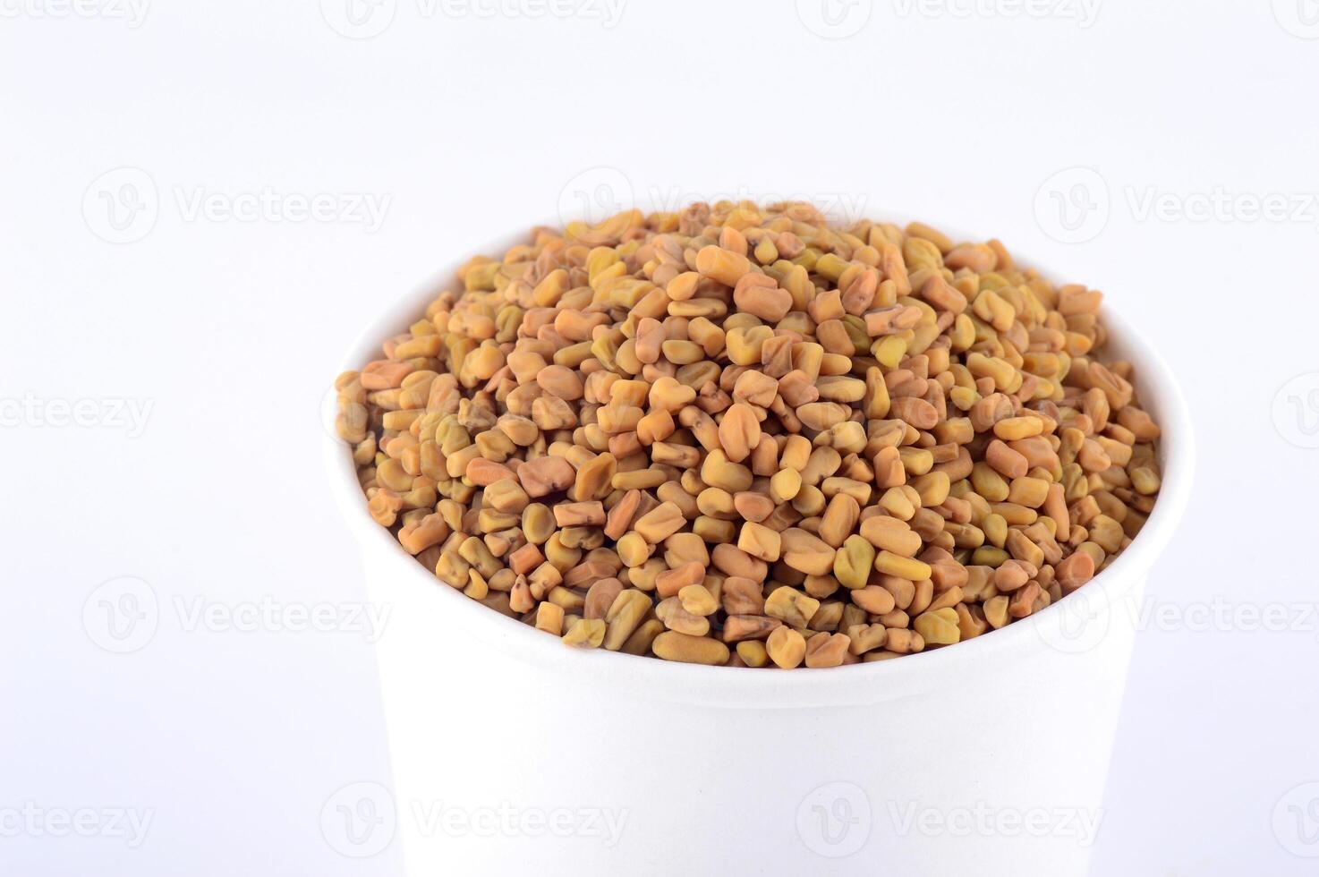 Fenugreek seeds in white plate isolated on white background photo