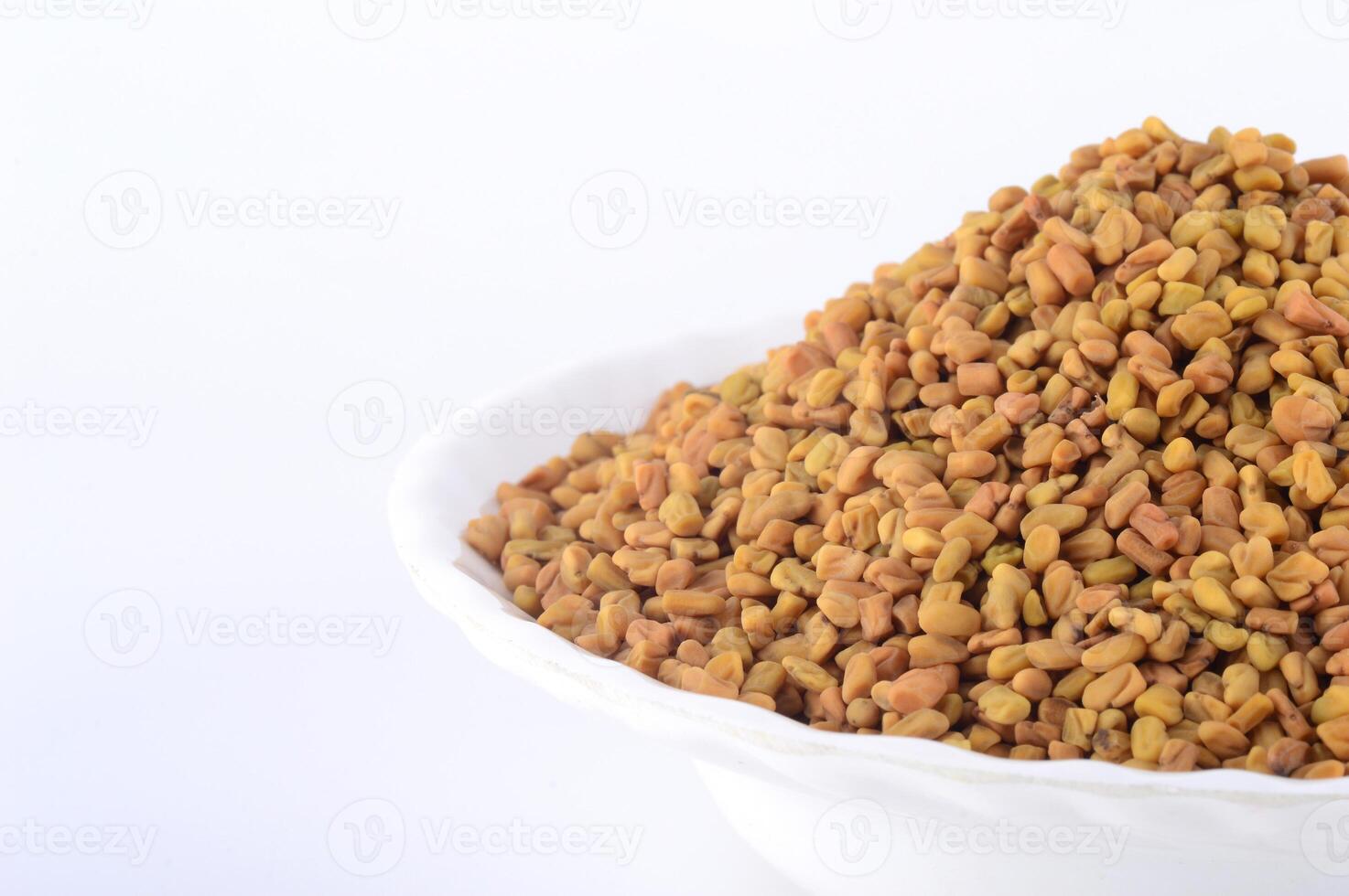 Fenugreek seeds in white plate isolated on white background photo