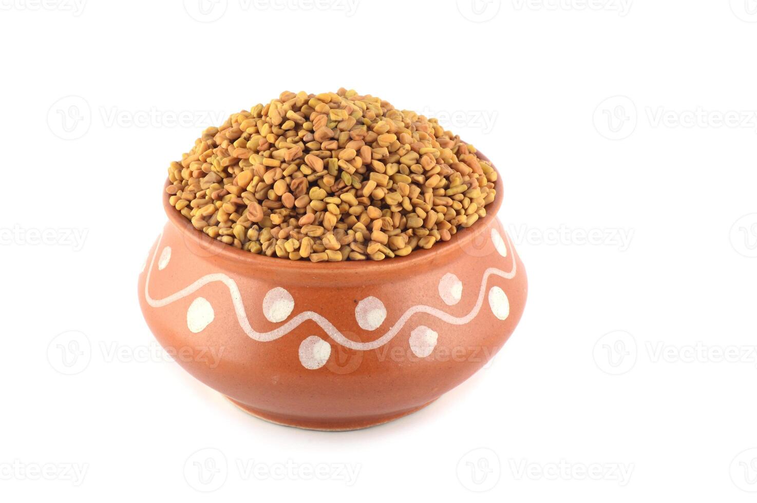 Fenugreek seeds in clay pot isolated on white background photo