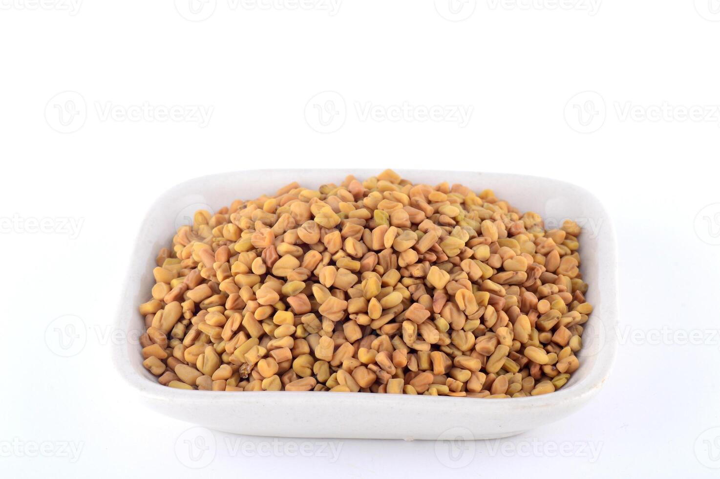 Fenugreek seeds in white plate isolated on white background photo