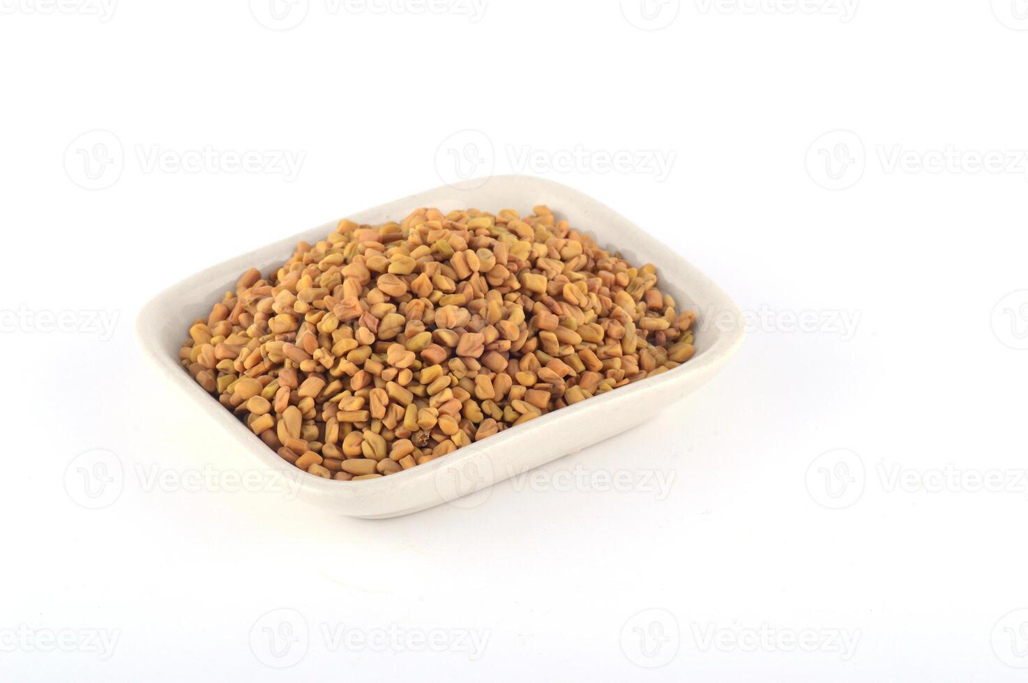 Fenugreek seeds in white plate isolated on white background photo