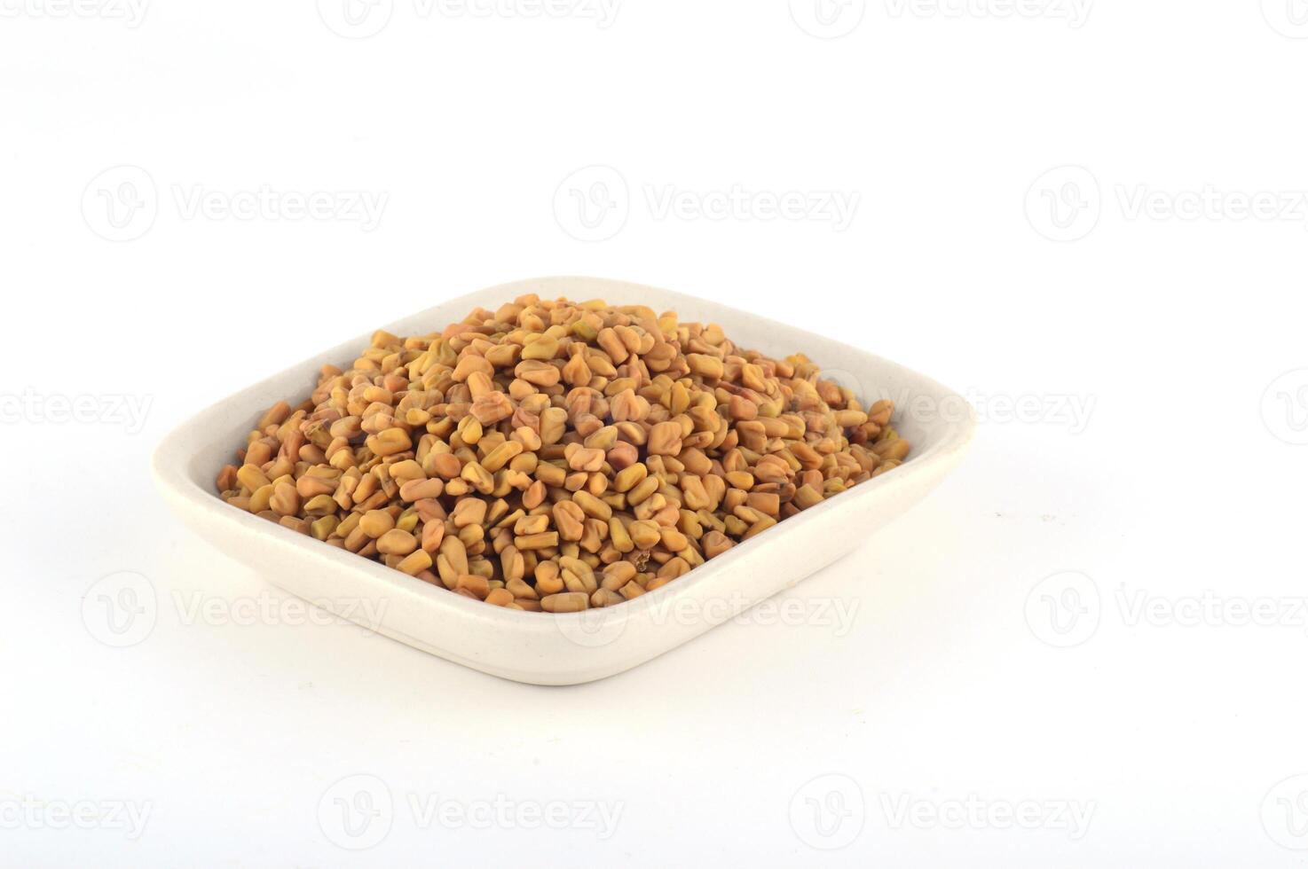Fenugreek seeds in white plate isolated on white background photo