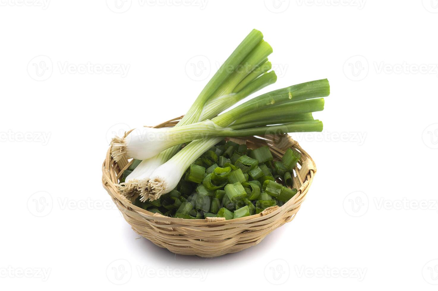 Fresh ripe green spring onions shallots or scallions with chopped onions in basket on white background photo