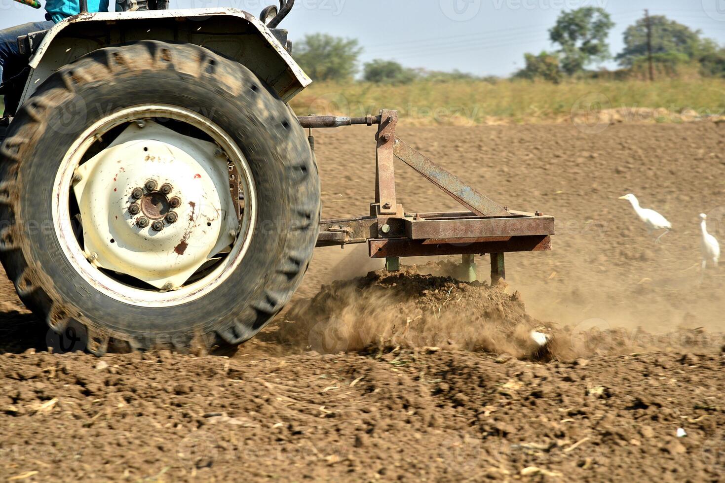 A tractor plowing a field with a plow photo