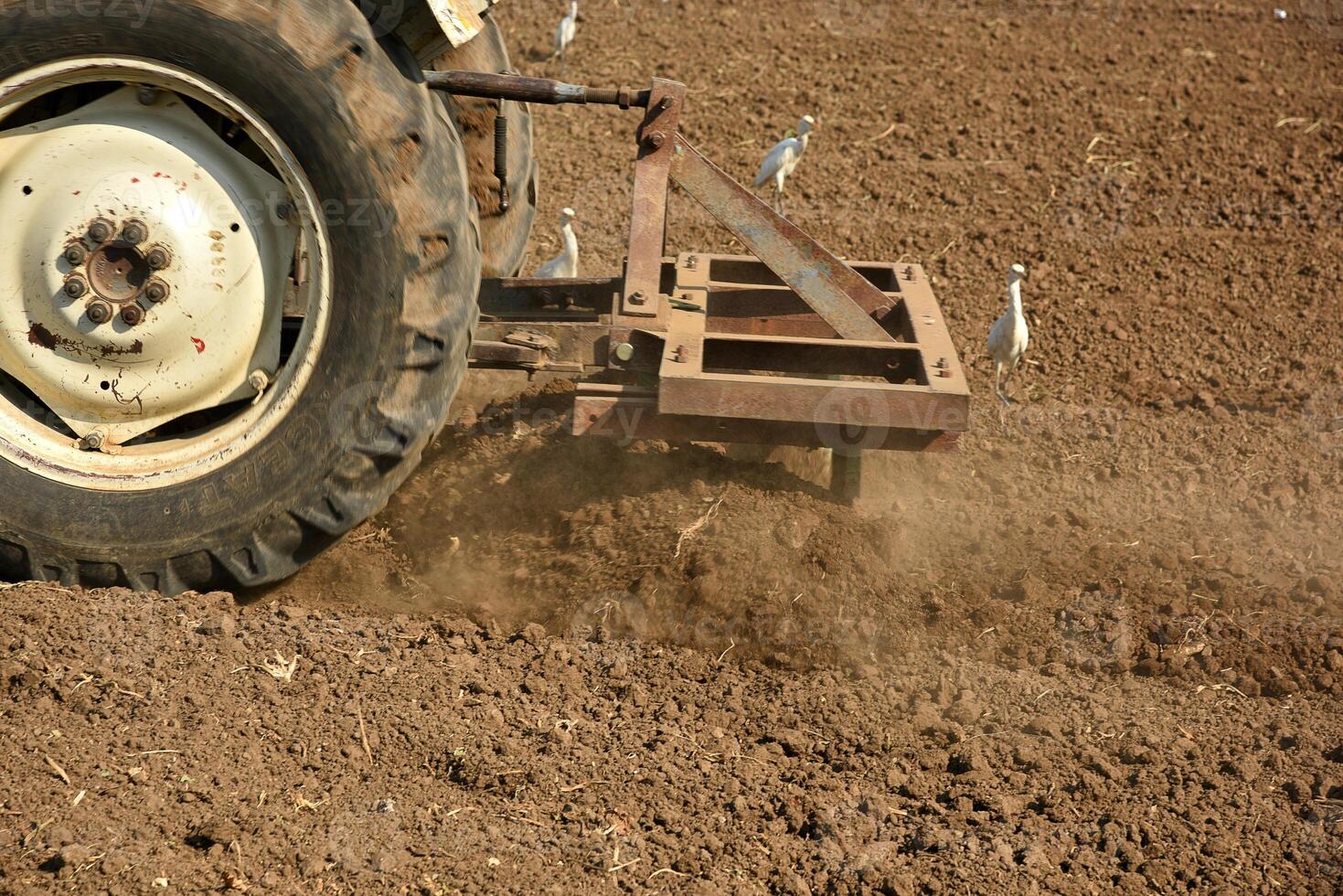 A tractor plowing a field with a plow photo