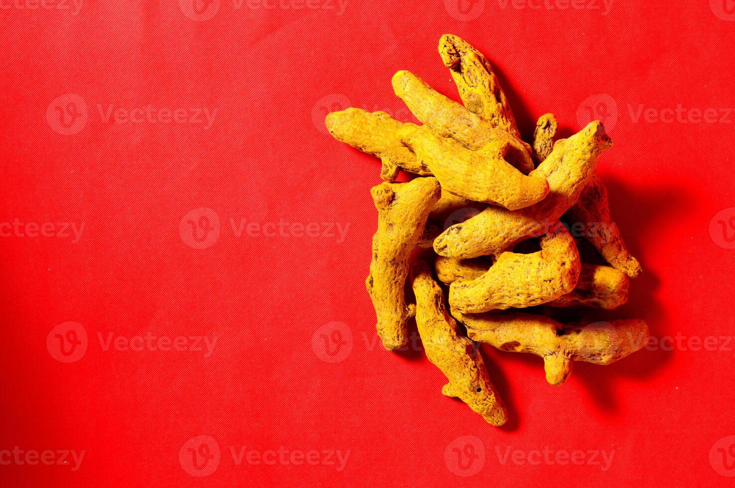 A pile of dried ginger on a red background photo