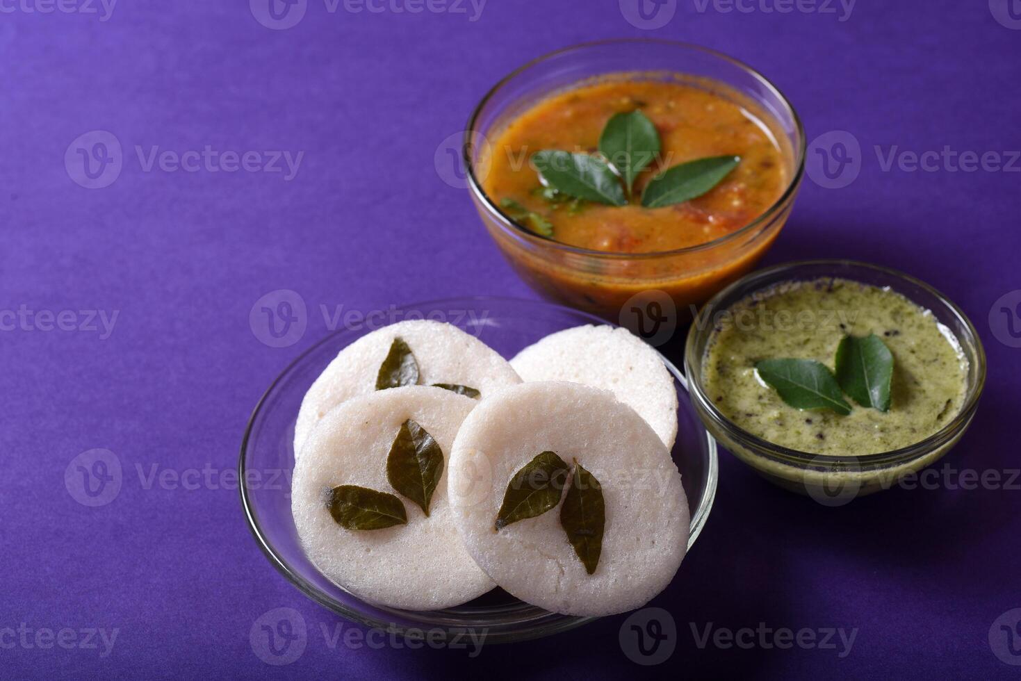 A bowl of food with a spoon and a small bowl of sauce photo